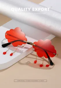 Close-up of red cloud-shaped rimless sunglasses with gold chain tassels and water drop pendants