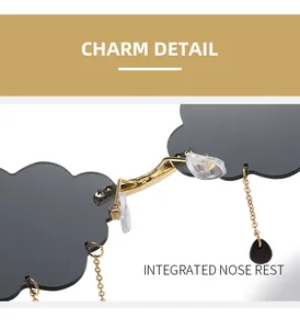 Detail of cloud-shaped sunglasses with golden bridge and black teardrop charms