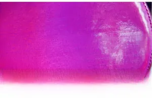 Macro shot of reflective holographic purple crossbody bag with fine texture finish