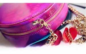 Detailed macro shot of holographic purple crossbody bag with premium gold metal zippers