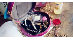 Macro view of metallic round crossbody bag showing internal capacity for phone and cosmetics