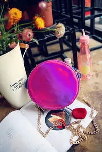 Detail of round holographic laser crossbody bag with shiny pink metallic finish and chain