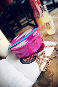 Detail of a pink laser holographic planet bag with silver wings and gold chain strap