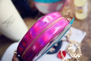 Detail of holographic round chain bag showing colorful reflective texture and gold zipper