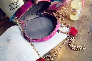 Detailed view of pink laser holographic round bag with golden chain and zipper closure