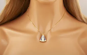Vue macro du pendentif croix en émail bleu plaqué or avec détails en cristal incrusté