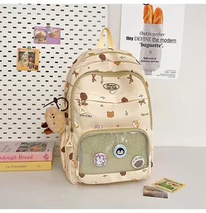 Detail of cute beige student backpack with transparent display pocket and bear charm
