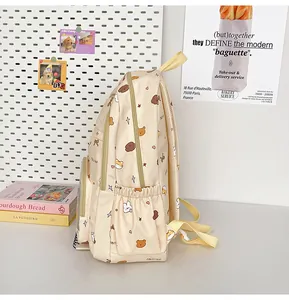 Detail of cream school backpack with cute cartoon prints and transparent front pocket