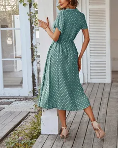 Detail der elastischen Taille und A-Linien-Silhouette an einem dunkelgrünen Punktkleid