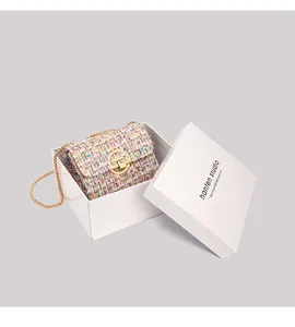 Detail shot of multicolor tweed chain bag with golden clasp in a minimalist gift box