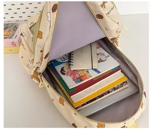 Detail view of large capacity beige backpack with internal laptop sleeve and school books