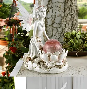 Detailed garden fairy statue with translucent wings holding a pink solar crackle glass ball