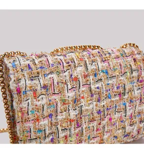 Close-up of colorful tweed texture and golden chain on this stylish shoulder bag