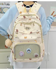 Close-up of cute school backpack with cartoon badges, plush pompom and heart patterns