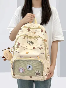 Detail showing transparent grid pocket with cute badges on a cream-yellow backpack