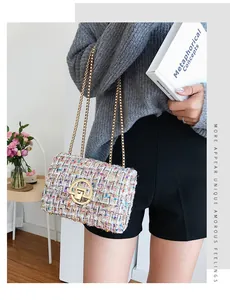 Close-up of multicolored tweed fabric texture and gold metal rotating lock on a shoulder bag