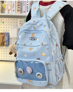 Detail view of light blue school backpack featuring cute cartoon prints and transparent mesh pocket