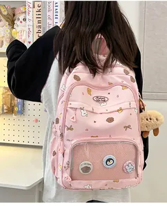 Pink cartoon backpack with heart patterns and clear pocket displaying cute badges