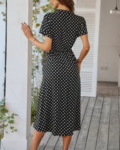 Rückansicht eines schwarzen Polka-Dot-Midikleids mit tailliertem Schnitt und weitem Rock