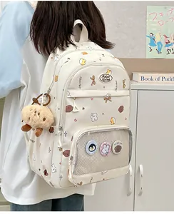 Detail of cream backpack with cartoon illustrations, mesh pocket and plush animal pendant