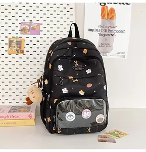 Detailed view of black student backpack featuring a transparent window with cute pins