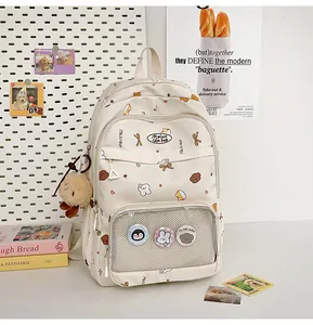 Close-up of cream student backpack with transparent pocket and cute badge inserts