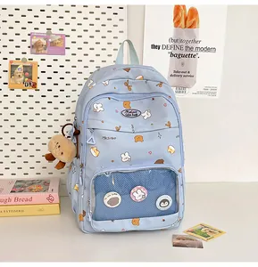Detail of light blue cartoon backpack featuring transparent window with anime badges