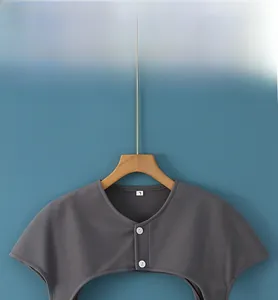 Detail view of the soft Dralon fabric shoulder warmer with grey buttons and collar tag