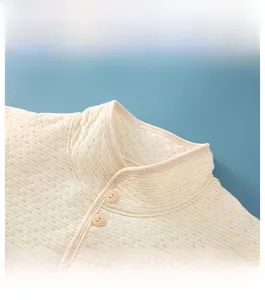 Detail of stand-up collar and buttons on thick beige striped quilted warm vest