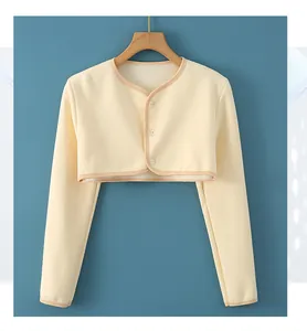 Detail of cream fleece shoulder warmer with wood hanger and three button closure