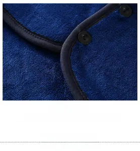 Detail of blue flannel shoulder wrap with black button and precise stitching