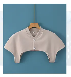 Dettaglio dello scaldaspalle beige con trama a maglia, colletto, bottoni e taglia L