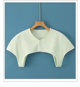 Detail of light green thermal shoulder warmer with two white buttons and L size tag
