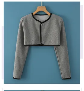 Detail of short grey knitted shoulder warmer with round neck and black trim accents