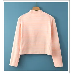 Detalle de la parte trasera de la camiseta térmica a rayas naranjas y blancas en percha