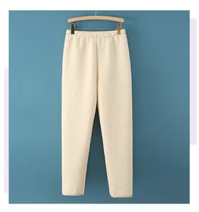 Close-up of cream white waffle texture pants with elastic high waist and thick fabric