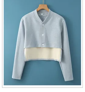 Detalle del dobladillo a capas y botones blancos en la chaqueta de hombro azul claro
