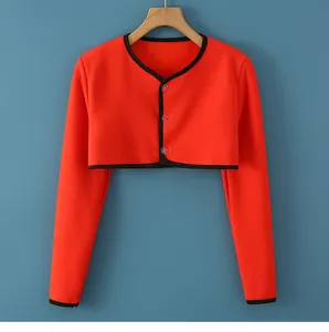 Detail of bright orange thermal shoulder wrap with black trim and three-button closure