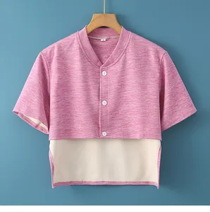 Detail of pink thermal shoulder warmer with white buttons on a wooden hanger