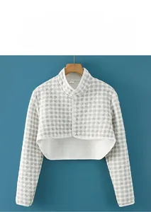 Close-up of gray checkered thermal shoulder wrap with buttons and quilted texture
