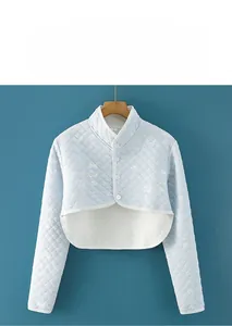 Macro detail of a light blue quilted shoulder protector with cotton fabric and buttons