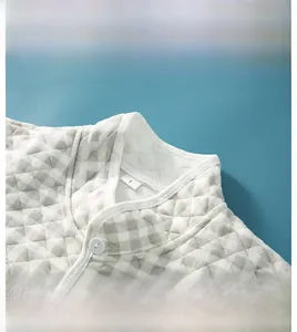 Detailed view of the quilted stand collar and gray checkered pattern on the shoulder warmer