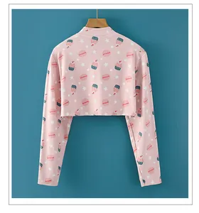 Primer plano de crop top rosa con estampados de postres y estrellas en pared azul