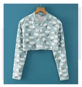 Detalle de la chaqueta corta de punto azul claro con estampado de nubes y botones