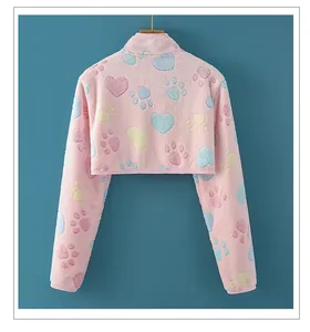 Détail du chauffe-épaule en flanelle rose avec des motifs de cœurs et de pattes colorés