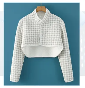 Detail view of quilted grey checkered shoulder wrap with button-up collar and long sleeves