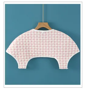 Detail of pink plaid quilted shoulder warmer with L size label and diamond stitching