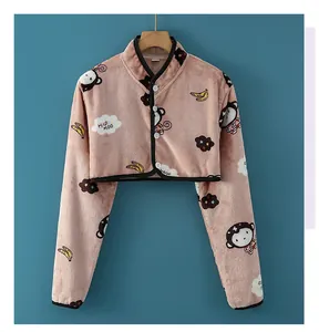 Detail of pink coral fleece shoulder wrap with cartoon monkey print and soft texture