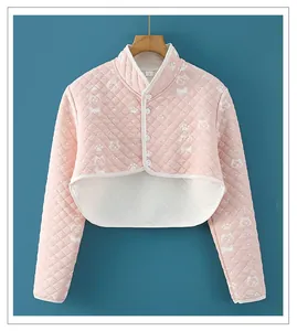 Detail view of pink quilted pet shoulder warmer with cute dog and cat prints and button closure