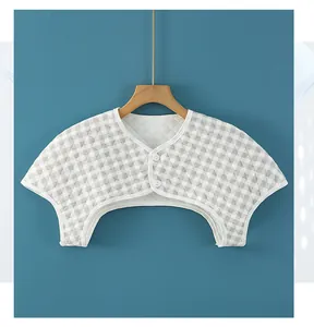 Detail of quilted cotton shoulder warmer with grey plaid pattern and two buttons